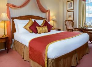 a bedroom with a large bed with red and yellow pillows at River Island Hotel in Castleisland