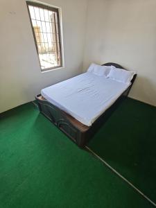 a bed in a room with a green floor at Gatlang Backpackers in Trisūli Bāzār