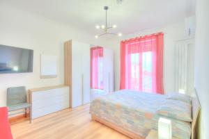a bedroom with a bed and a tv and windows at La casetta al mercato in Civitavecchia