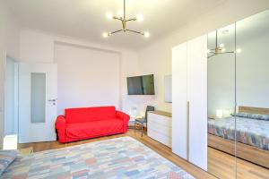 a bedroom with a red chair and a bed at La casetta al mercato in Civitavecchia