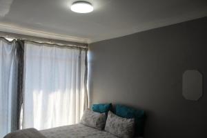 a bedroom with a bed in front of a window at Penthouse in Bloemfontein