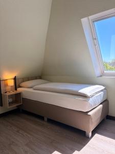 a bedroom with two beds and a window at Schlüter Hotel & Restaurant in Wankendorf