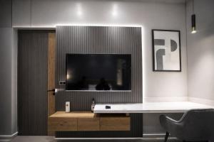 a living room with a large tv on a wall at The Cozy Chaos - Spa Jacuzzi -Private Terrace - Taj Mahal in Agra