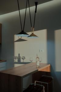 a kitchen with two lights and a table with glasses at Lefka Apartment in Vivari
