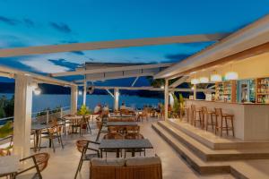 a restaurant with tables and chairs and a bar at Lefka Apartment in Vivari