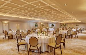 a banquet room with white tables and chairs at Killarney Avenue in Killarney