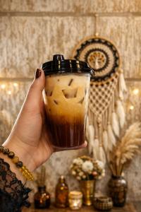 a person holding a cup of coffee in their hand at The Cozy Chaos - Spa Jacuzzi -Private Terrace - Taj Mahal in Agra