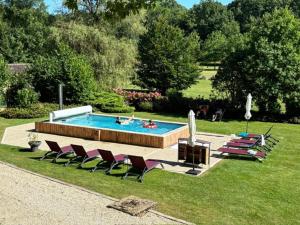 a pool with a bunch of chairs and a group ofiuses at Domaine de Thironne Lac & Nature in Montigny-le-Chartif