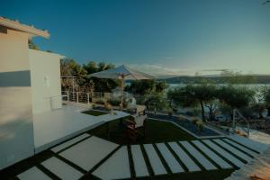 a house with a patio with an umbrella at Lefka Apartment in Vivari