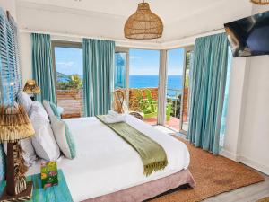 a bedroom with a large bed with a view of the ocean at VistaBlu Camps Bay in Cape Town