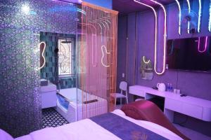 a purple room with a bed and a bathroom at Haven Hotel in Ho Chi Minh City +2 photos