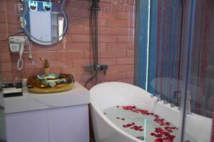 a bathroom with a tub and a sink and a mirror at Haven Hotel in Ho Chi Minh City