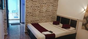 a bed in a room with a brick wall at Bluebell Holiday Inn in Yercaud +10 photos