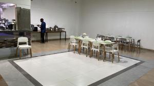 a man standing in a kitchen with tables and chairs at Hotel Monte Verde in Beira