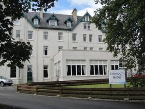 a large building with a clock on the front of it at Dornoch Hotel 'A Bespoke Hotel' in Dornoch