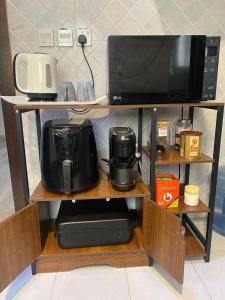 a shelf with a microwave and a coffee maker at RUBA apartment in Dammam +31 photos