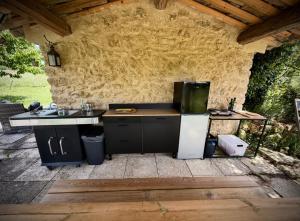 an outdoor kitchen with a sink and a refrigerator at Cabanon bucolique face au Luberon in Lourmarin