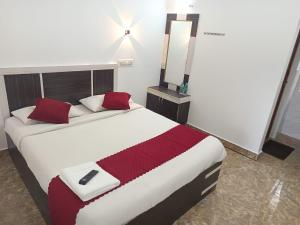 a bedroom with a bed with a remote control on it at Bluebell Holiday Inn in Yercaud
