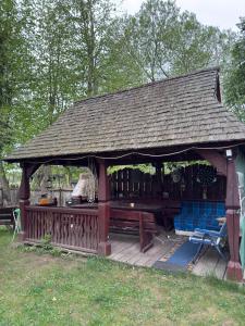 a wooden gazebo with a bench and a table at Domek Pod Skansenem in Białowieża