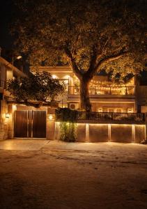 a building with a tree in front of it at night at The Cozy Chaos - Spa Jacuzzi -Private Terrace - Taj Mahal in Agra