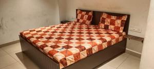 a bed with a checkered quilt on it in a room at AB Merridien in Coimbatore +9 photos