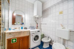 a bathroom with a washing machine and a toilet at Sweet home rp – t1 em portimão in Portimão +18 photos