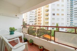 a balcony with a white chair and a white table at Sweet home rp – t1 em portimão in Portimão