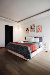 a bedroom with a large bed and a wooden floor at Hôtel Touraco in Assinie +62 photos