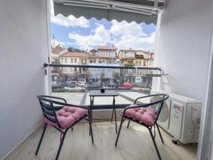 a balcony with a table and two chairs and a window at The Spot Apartments in Ohrid