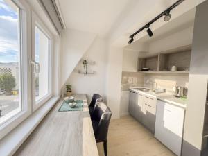 a kitchen with a table and a large window at The Spot Apartments in Ohrid