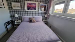 a small bedroom with a bed with a window at Innisfail Edi - double room with private bathroom in Edinburgh
