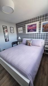 a bedroom with a large bed with purple sheets at Innisfail Edi - double room with private bathroom in Edinburgh