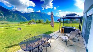a patio with a table and chairs and an umbrella at Appartement 2,5 pièces et SPA in Chamoson