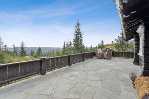 a patio with a fence and chairs on it at Orreleiken in Åmot