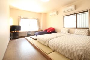 a bedroom with two beds and a television in it at 水之道 in Osaka