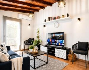 a living room with a couch and a tv at Romantic loft in Tríkala