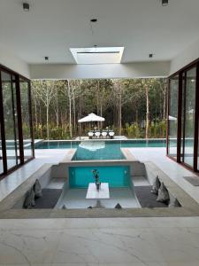 a swimming pool with a table in the middle of a house at Encore by Serenity in Hampāpura +7 photos