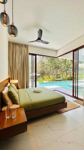 a bedroom with a large bed and a pool at Encore by Serenity in Hampāpura
