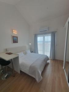 a bedroom with a bed and a desk and a window at Apartments Marti in Murter
