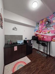 a kitchen with a counter and a bar in a room at K Avenue by Stay & Unwind Suites in Donggongon