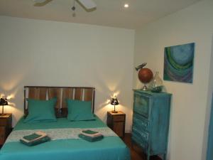 a bedroom with a green bed with two towels on it at Au Bois de la Grave in Luzech