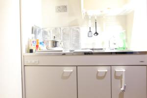 a kitchen with white cabinets and a sink at 水之道 in Osaka +17 photos