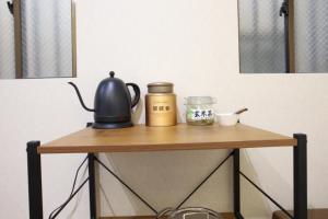 a table with a tea kettle and jars on it at 水之道 in Osaka