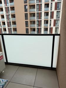 a large white screen on a balcony with a tall building at Sterling House in Timişoara
