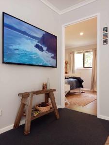 a living room with a television on a wall at Beach & Forest Stay in Port Arthur