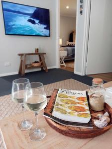 a table with two glasses of wine and a book at Beach & Forest Stay in Port Arthur +31 photos
