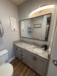a bathroom with a sink and a toilet and a mirror at Spacious Gatlinburg Condo With Million Dollar Mountain Views in Gatlinburg +16 photos