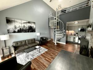 a living room with a couch and a spiral staircase at Spacious Gatlinburg Condo With Million Dollar Mountain Views in Gatlinburg