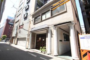 a building with columns on the side of a street at 水之道 in Osaka