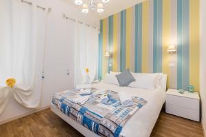 ein Schlafzimmer mit einem Bett mit einer bunten gestreiften Wand in der Unterkunft Rione Monti Suites in Rom